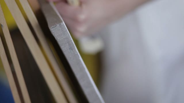Easel Close Up. Hand Holds The Brush