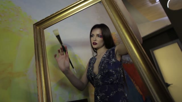 Woman Paints With A Brush In An Empty Picture Frame
