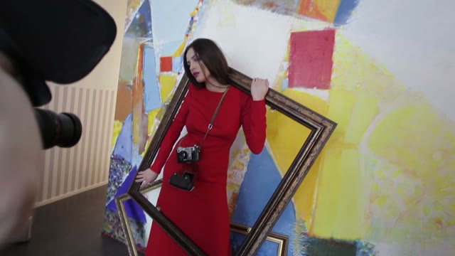 Photographer Takes Pictures Of A Girl Posing In A Picture Frame