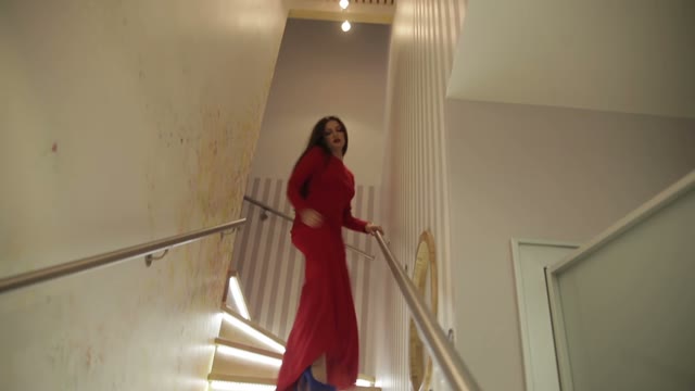 Model In A Red Dress Posing On The Stairs