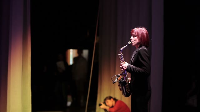 Woman In Suit Playing Saxophone