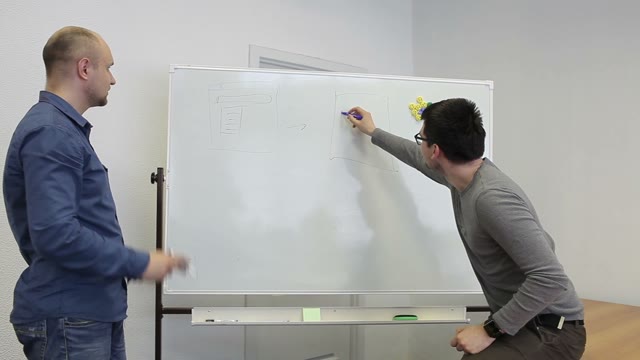 Two Man Draw Diagrams On The White Board And Discuss