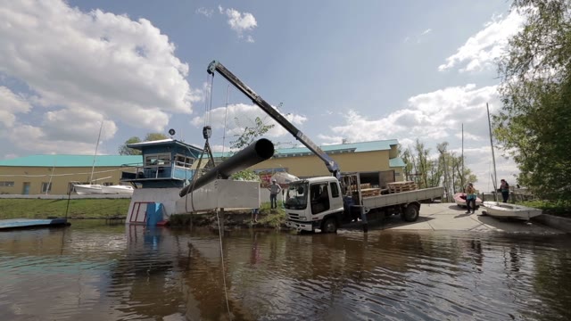 Loading Pipes Into The Water