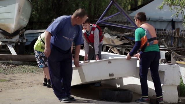 Man And Children Carry The Boat