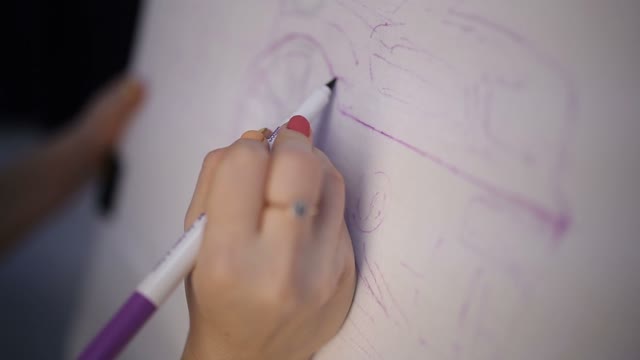 The Woman Draws A Car On Fabric With Markers