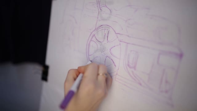 The Woman Draws A Car On Fabric With Markers