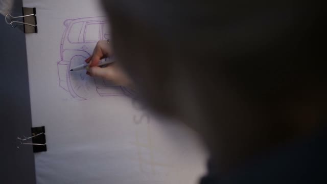 The Woman Draws A Car On Fabric With Markers