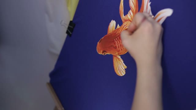 The Hand Of A Girl With A Brush. Draws A Fish
