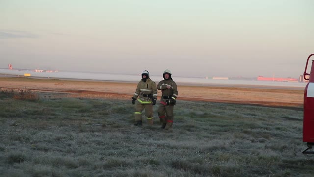 Two Rescuer Fireman Going Across The Field.