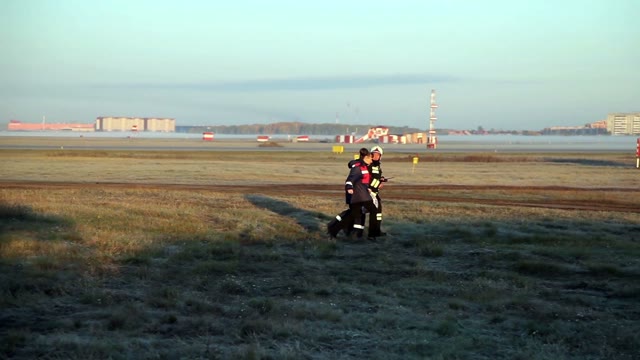 Firefighter And Medics Running Across The Field