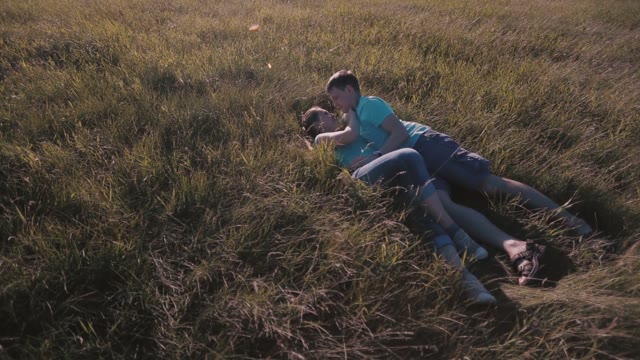 Loving Couple Lying On The Grass And Kissing