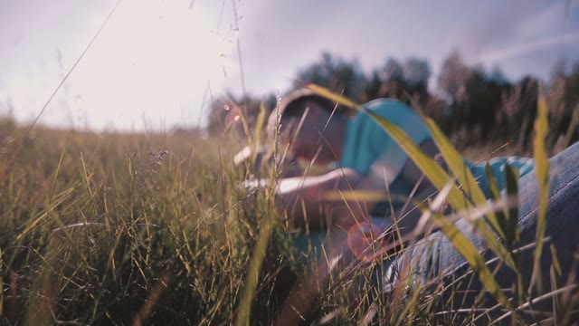 Beautiful Couple Lying On The Grass And Kissing