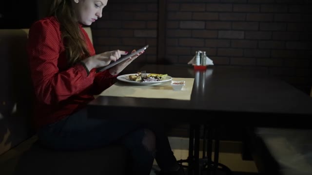 Beautiful Girl Works With The Tablet At The Table Cafe.