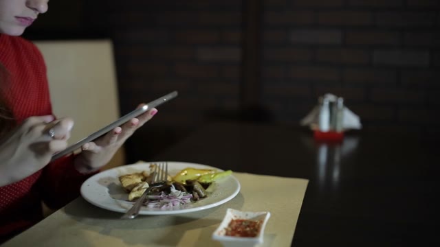 Beautiful Girl Works With The Tablet At The Table Cafe.