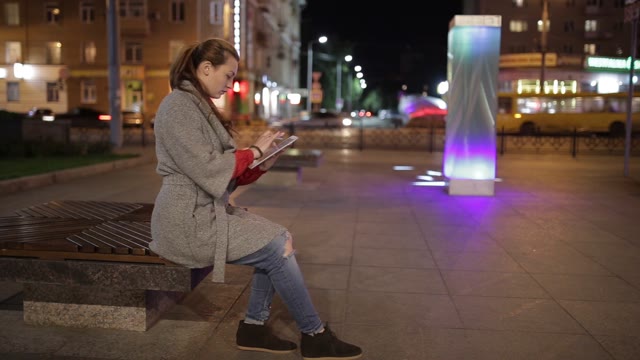 Cute Woman Using Tablet Outdoors In The Evening.