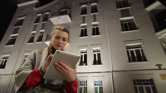 Cute Woman Using A Tablet In The Evening Outdoors In The Fall.
