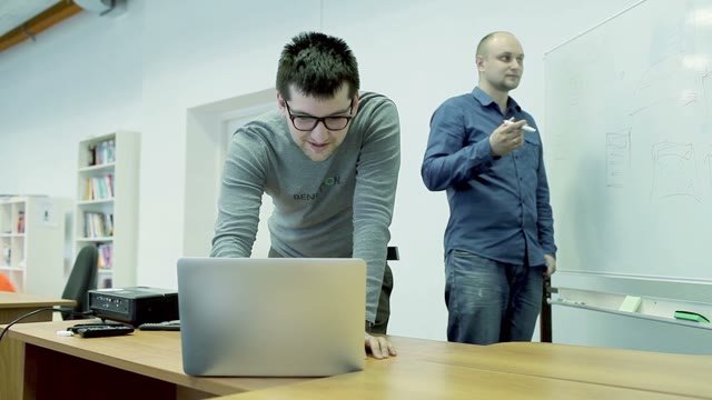 The Man Explains Something To A Colleague, And Draws Schemes On The Board