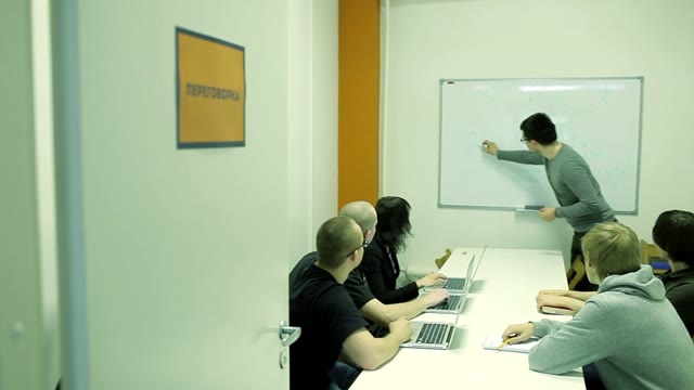 The Young Man Draws Something On The Board And Explain Educational Material