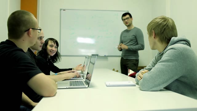 A Small Group With Laptops Discuss Something With The Lecturer In A Small