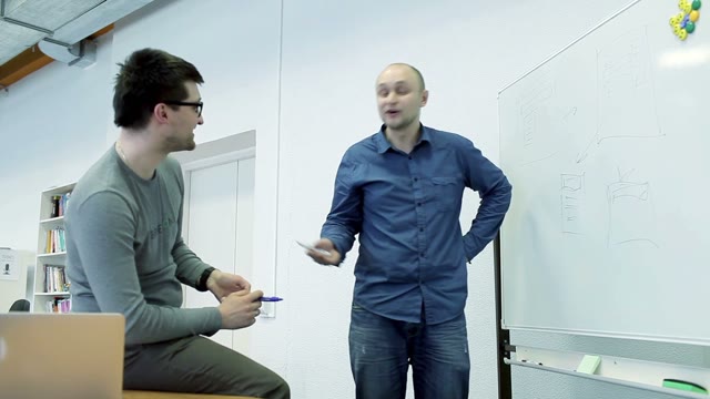 Colleagues Marker Paint Scheme On A White Board And Talk About Business