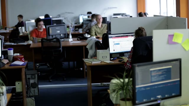 People Working At Computers In The Workplace
