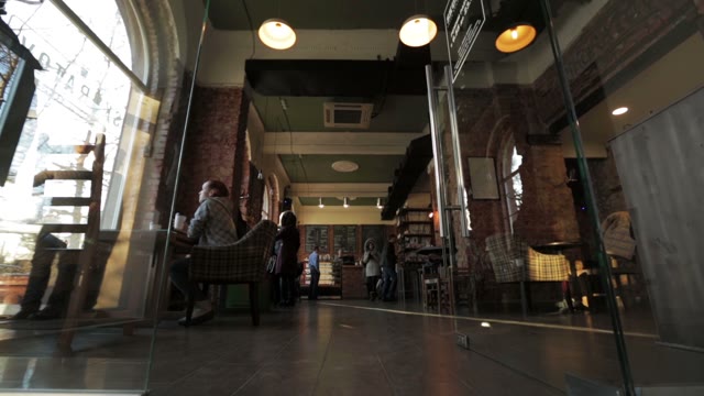 A Woman In A Green Sweater Comes In A Coffee House
