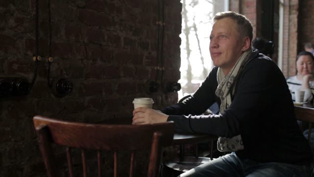 A Man With A Cup Of Coffee Looking And Smiling
