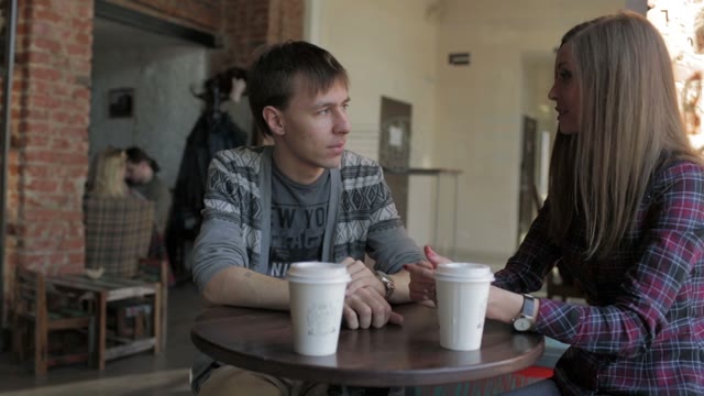 Young Couple In A Coffee Shop At A Table Talking
