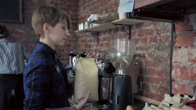 Young Girl With A Tattoo Pours Coffee Grinder