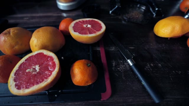 Close-up Of Cut In Half Juicy Grapefruit On A Black Cutting Board