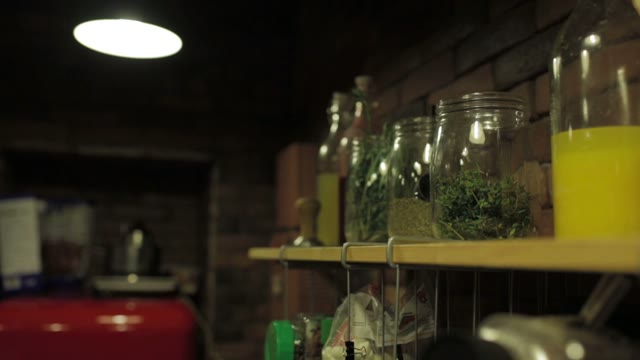 Girl Takes A Glass Jar Of Herbs From The Shelf