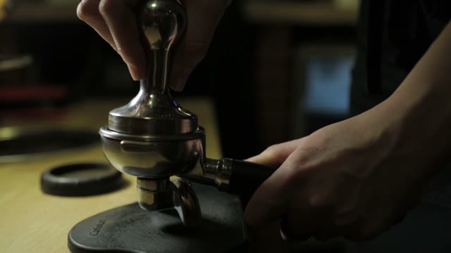 Barista Tamping The Grind Coffee For Espresso