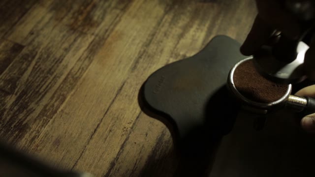 Young Man Tamping Cooffee Before Brewing