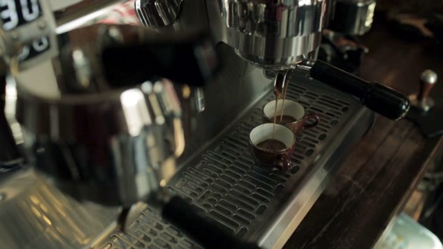 Two Cups Of Coffee Being Poured From A Espresso Machine