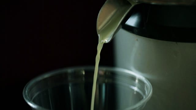The Juice From The Juicer Is Poured Into A Cup