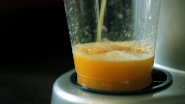 The Juice From The Juicer Is Poured Into A Cup. Close-up