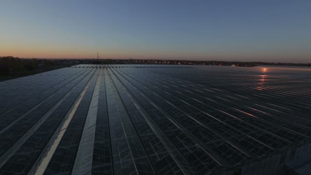 Large Industrial Building With A Glass Angled Roof Reflecting The Sun's Rays