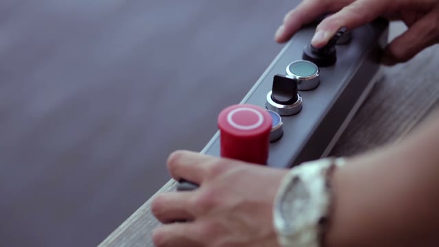 Man Controls The Reversing Winch With Remote Control Close-up.