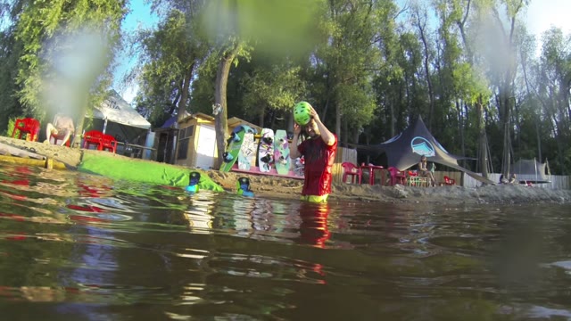 Funny Man With A Wakeboard Pours Water On The Camera From The Helmet.