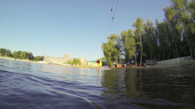 A Young Man Rides A Wakeboard Over The Action Camera. Slow Motion.
