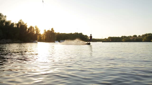 A Young Man Riding A Wakeboard At Sunset