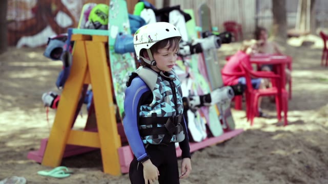 Small Wakeboarder Ready To Start. On It The Helmet And Suit.