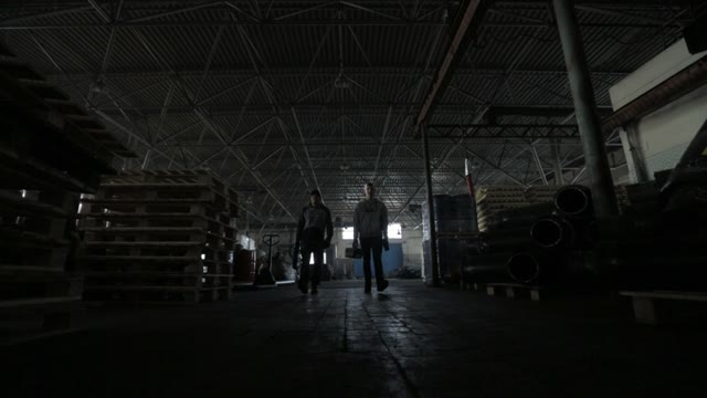 Two Young Workers Go To The Production Of The Tool At The Camera