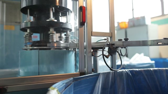 Blue Plastic Bottle Caps Fall From Conveyor To The Box.