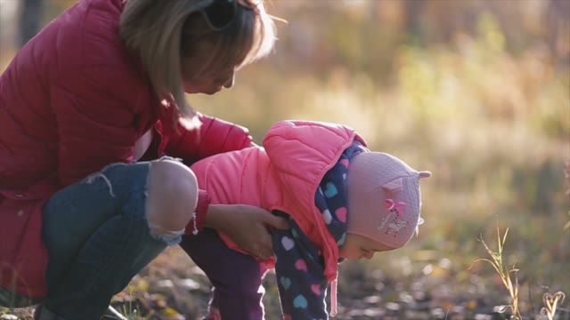 The Child Makes The First Steps. Mom And Dad To Help Him.