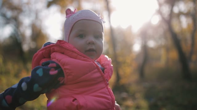 Cute Baby On A Background Autumn Forest. The Sun Is Shining.