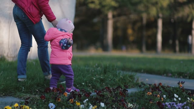 Mother And Little Daughter Walking In The Park.