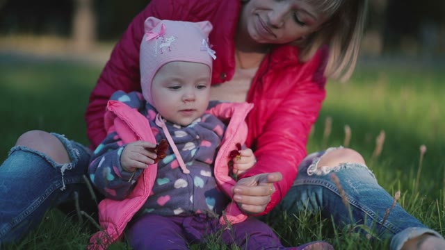 The Mother Gives Her Little Daughter To Smell The Grass.