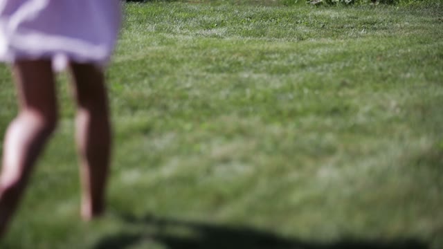 Little Girl In Pink Skirt Runs On The Lawn