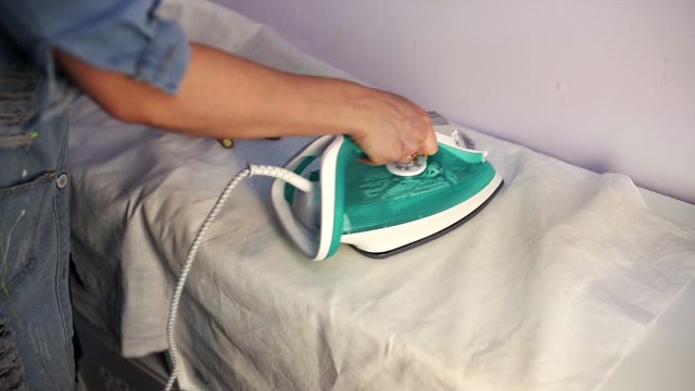 Woman Ironing Shirt Iron Through A Sheet.